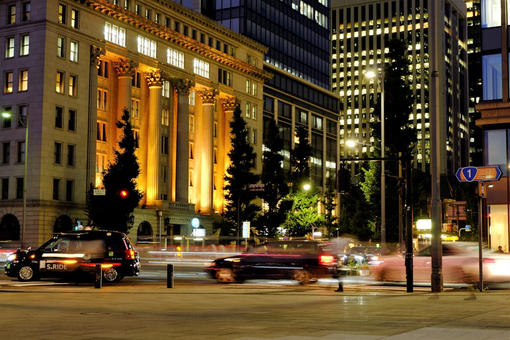 cars on road near high rise building during night time