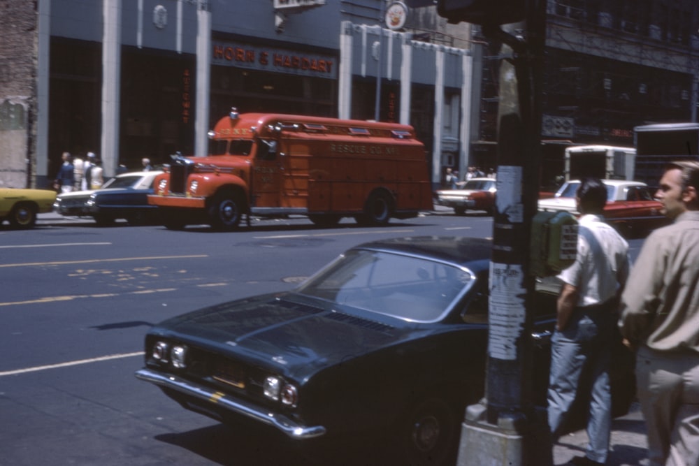 man in white shirt standing beside black car during daytime