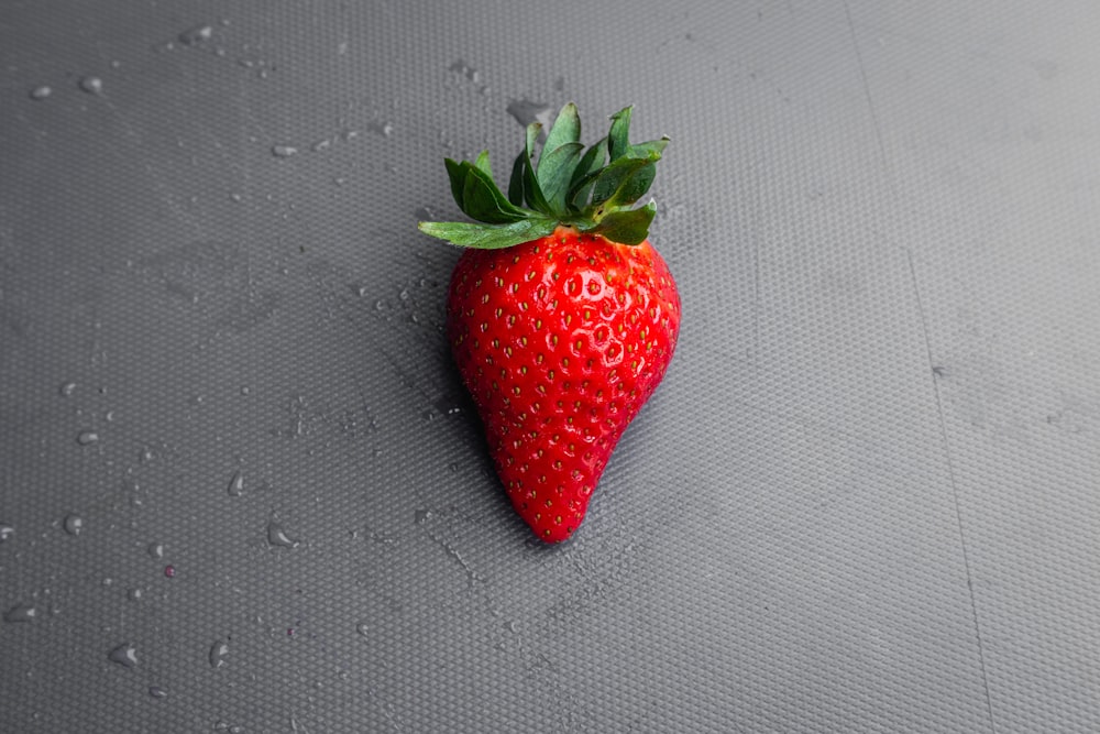 red strawberry on gray textile
