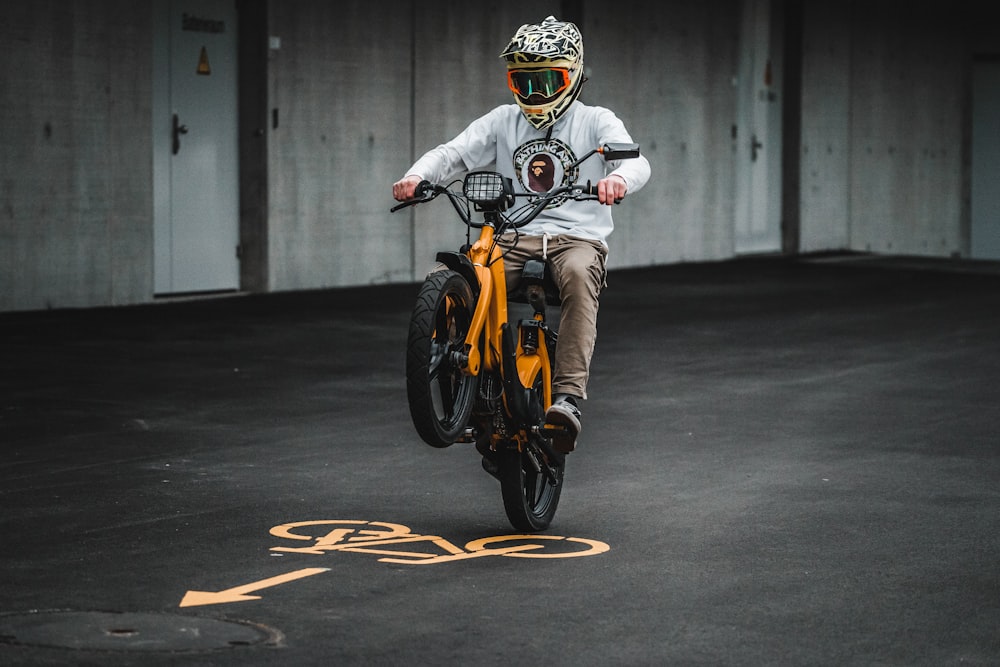 hombre con chaqueta blanca montando motocicleta naranja