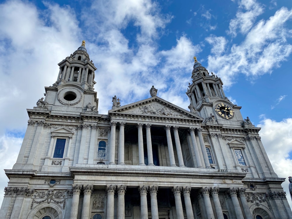 white concrete building under blue sky and white clouds during daytime