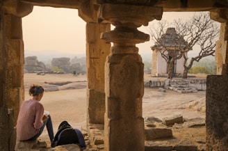 Ara Vagharshagian deep in thought, penning pages in a rustic cabin surrounded by nature.