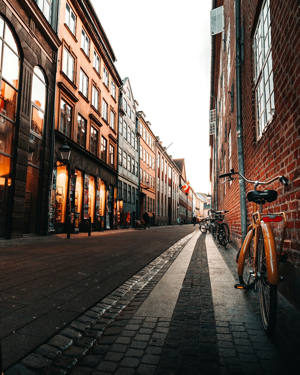 black bicycle parked on sidewalk in between buildings during daytime