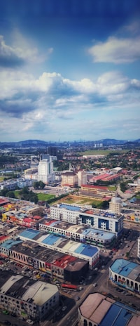Scenic view of Cusco city streets blending traditional Andean culture with modern life, under a teal sky.