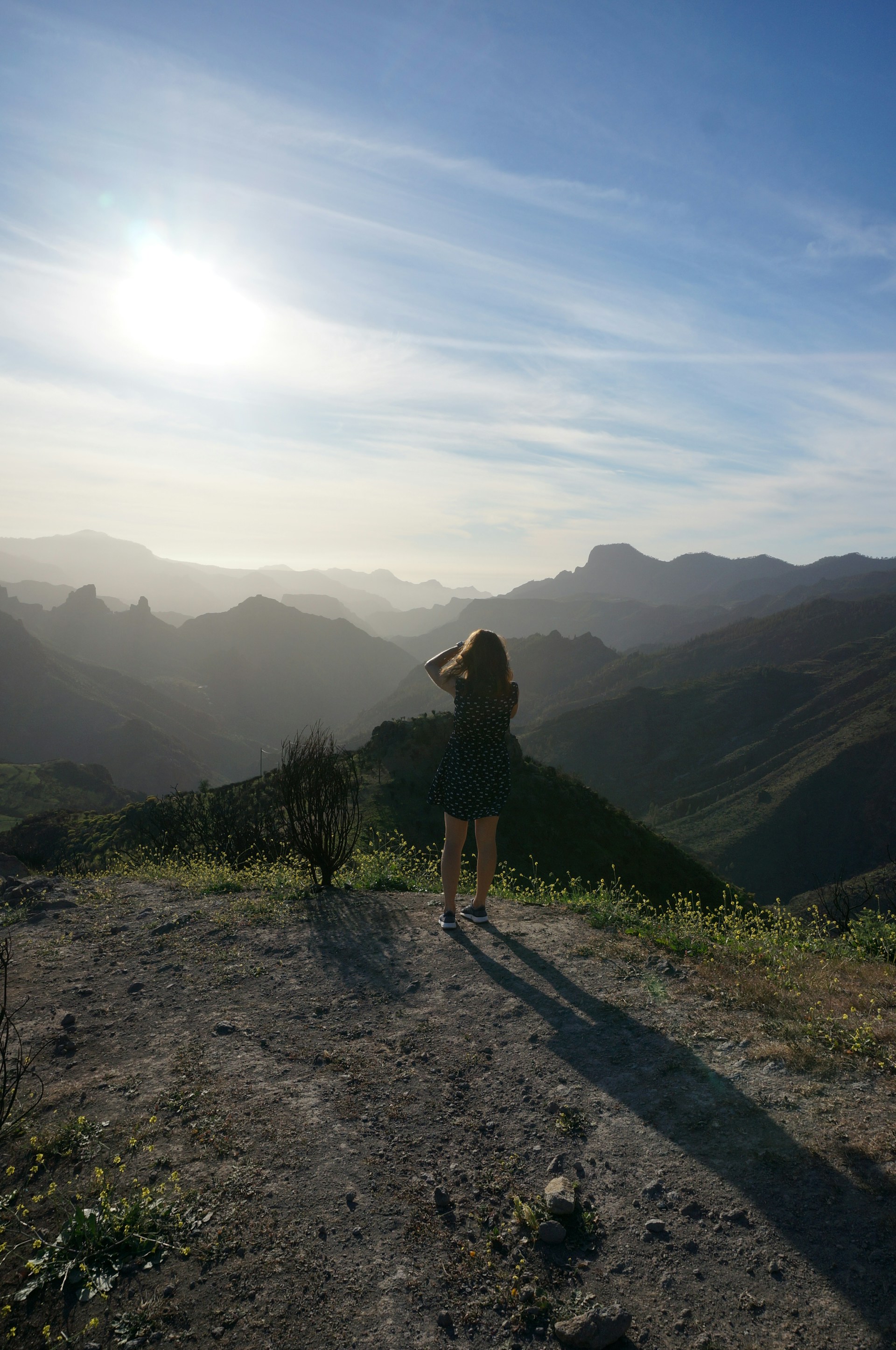 woman in black dress standing on brown dirt road during daytime
