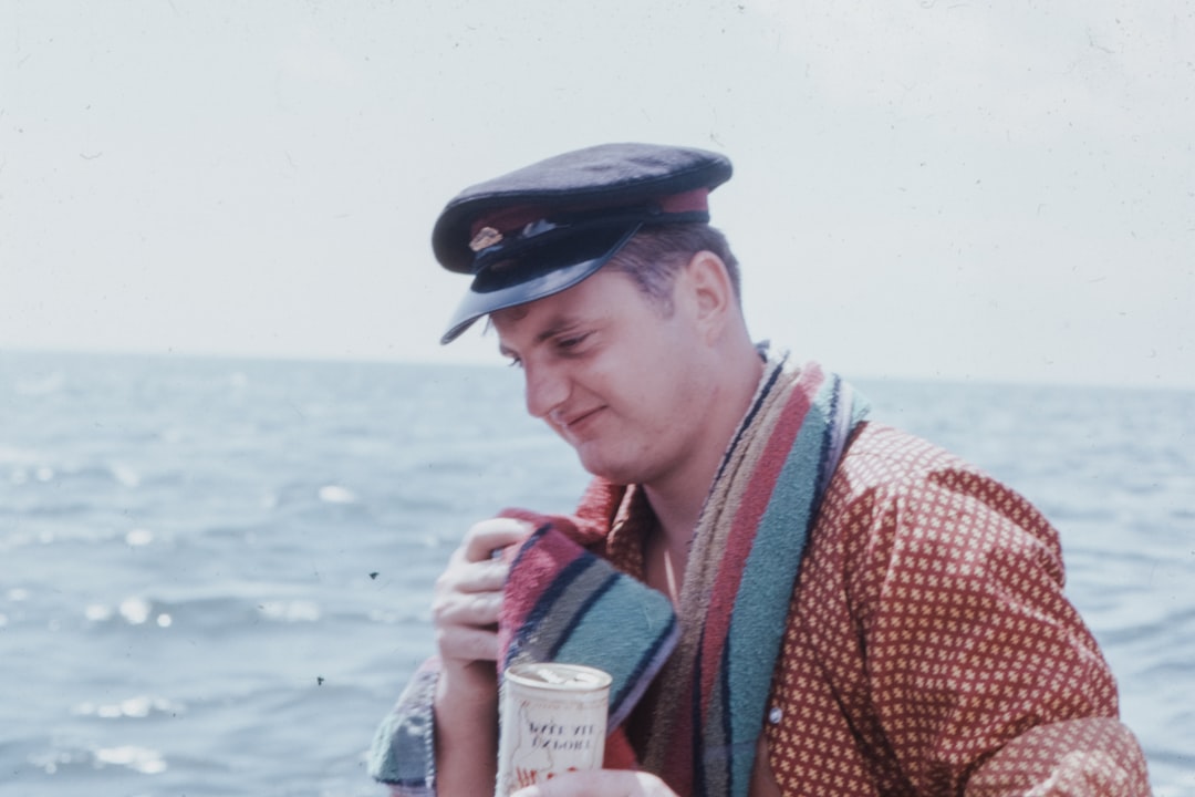 man in red and white checkered dress shirt holding white cup