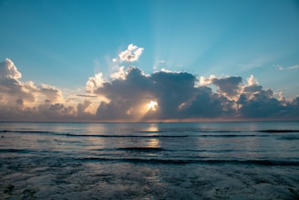 ocean under blue and white cloudy sky during daytime