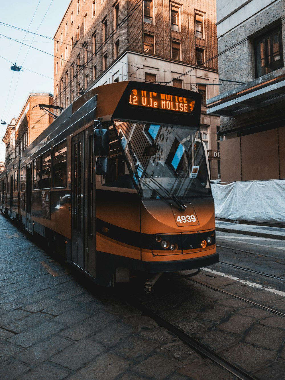 yellow and black tram on road during daytime