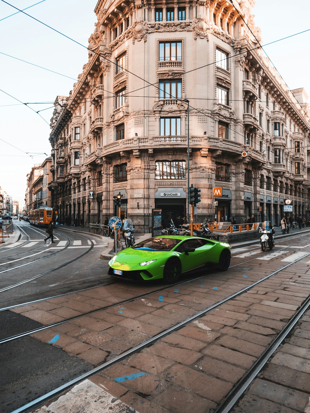 green car on road near building during daytime