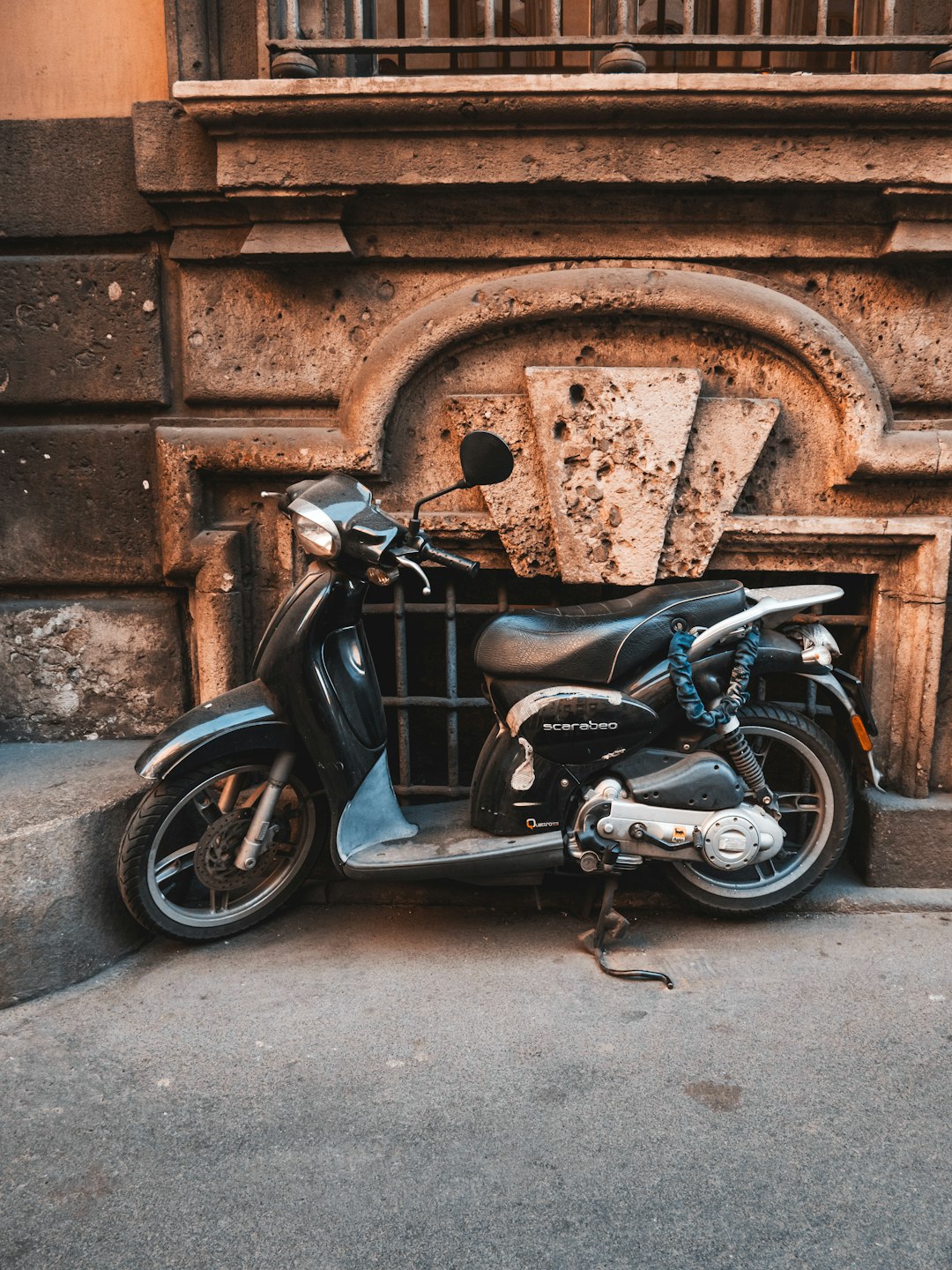 black motorcycle parked beside brown brick wall