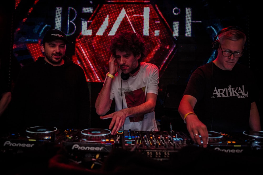 man in black crew neck t-shirt standing beside dj mixer