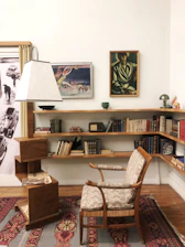 Cozy reading nook with vintage armchair and Monet prints on the wall.