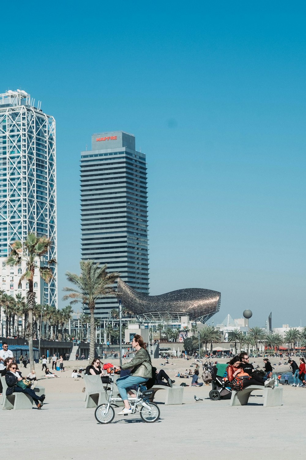 people sitting on bench near high rise buildings during daytime