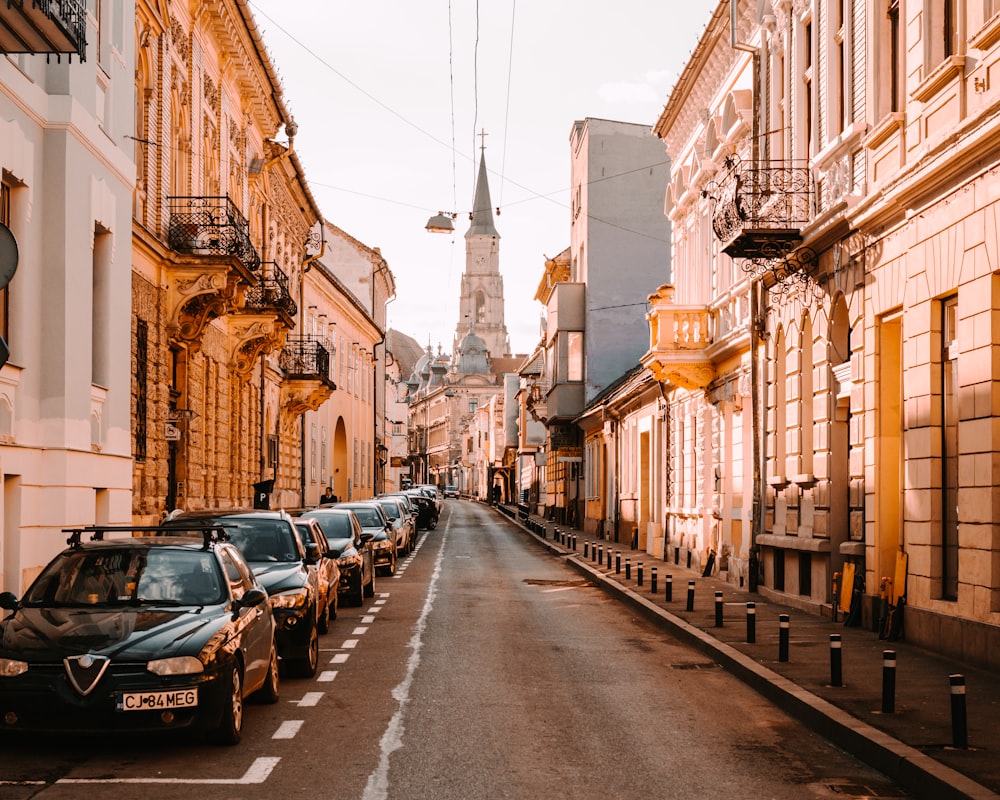 cars parked on side of the road in between buildings during daytime