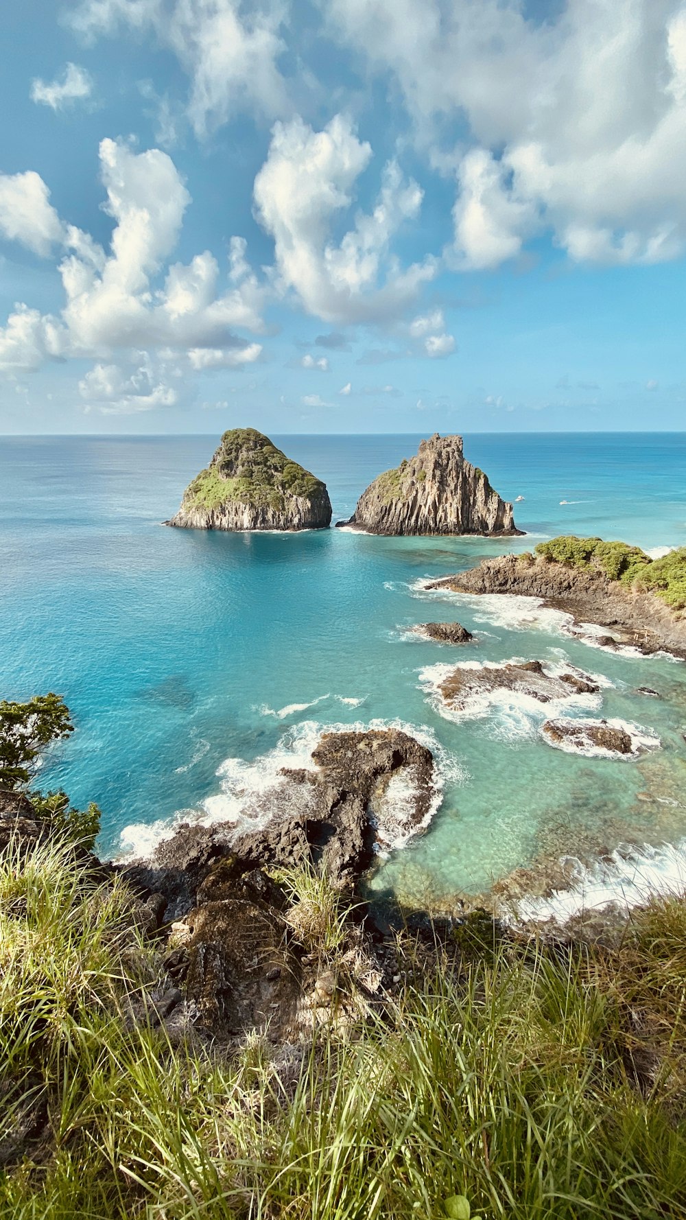 brown rock formation on sea under blue sky during daytime