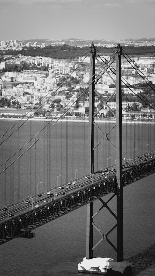 grayscale photo of bridge over river in Cristo Rei Portugal