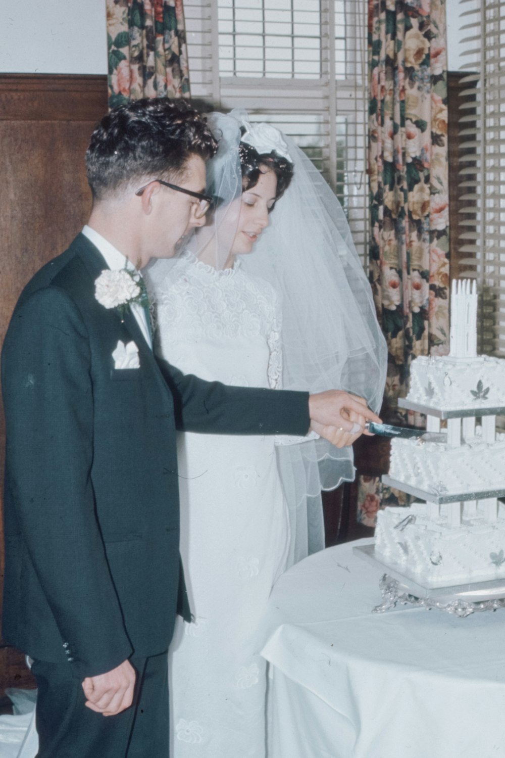 man in gray suit jacket holding a woman in white dress