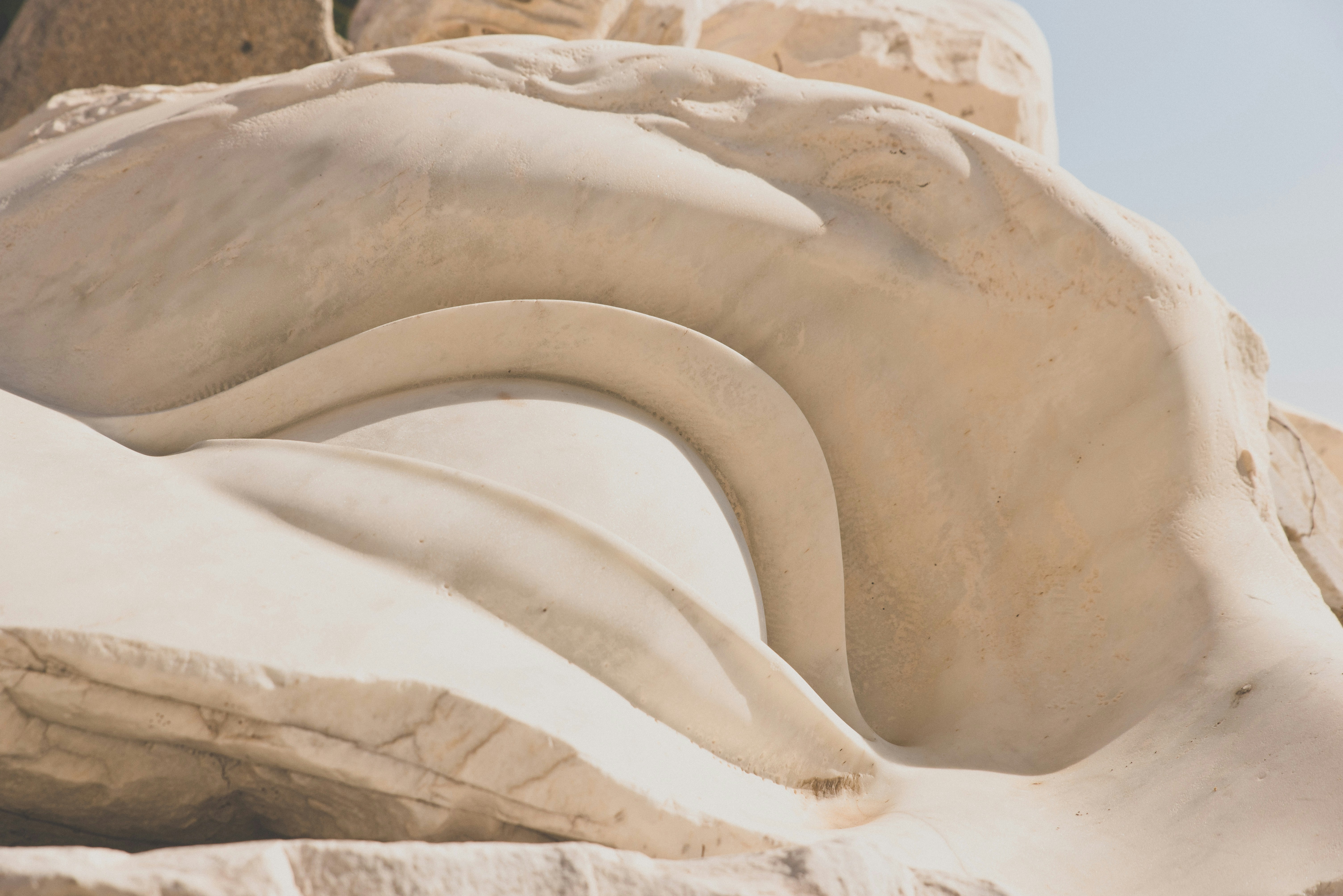brown rock formation during daytime, Giant marble sculpture of an eye in antic greek style