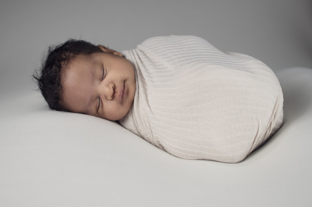 woman in white knit sweater lying on bed