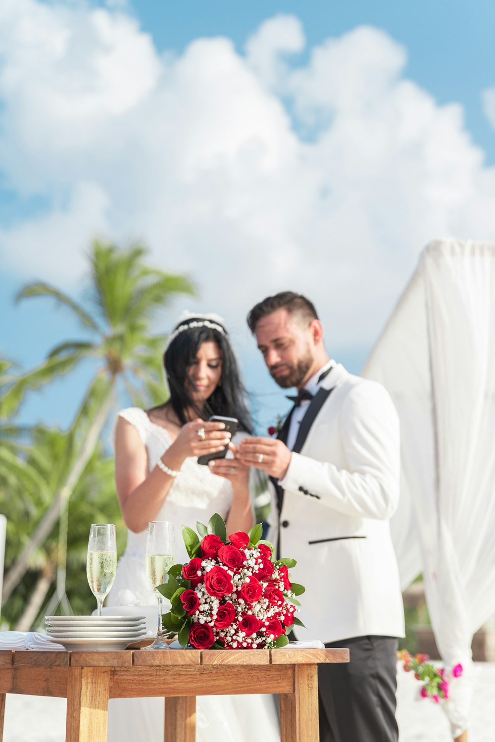 man in white suit kissing woman in white wedding dress