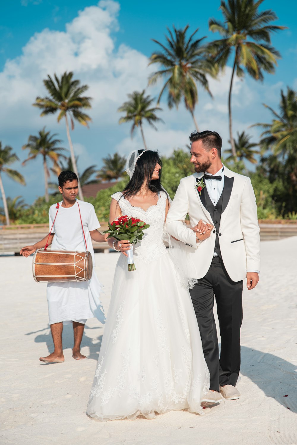 Mann im schwarzen Anzug steht neben Frau im weißen Brautkleid
