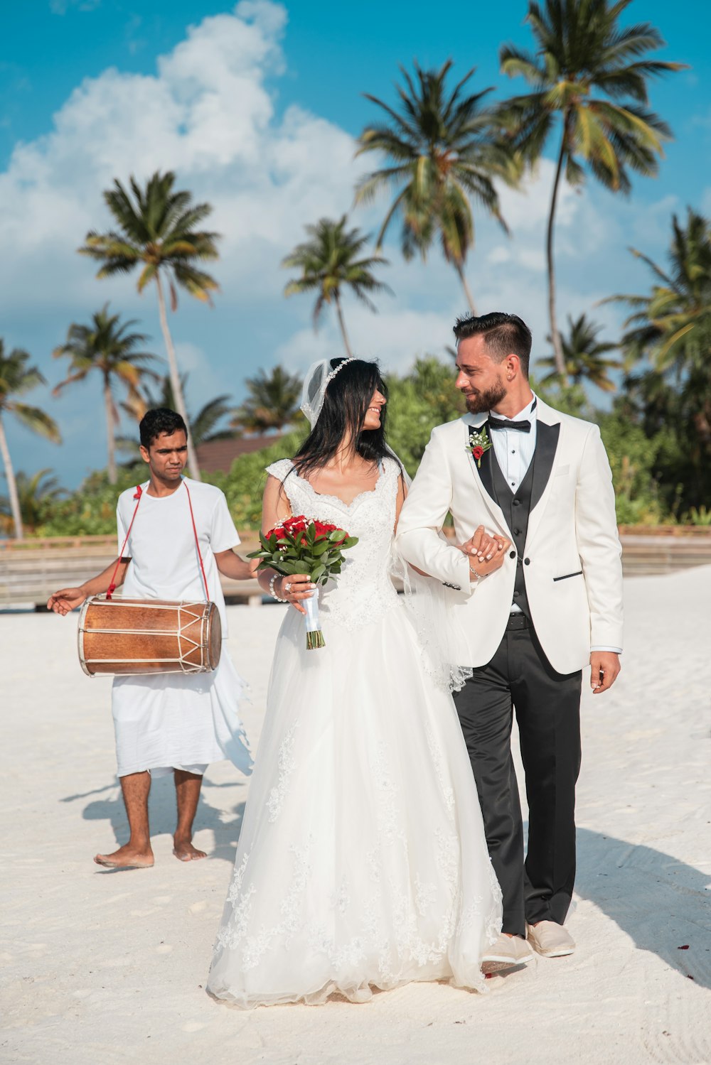 man in black suit standing beside woman in white wedding dress