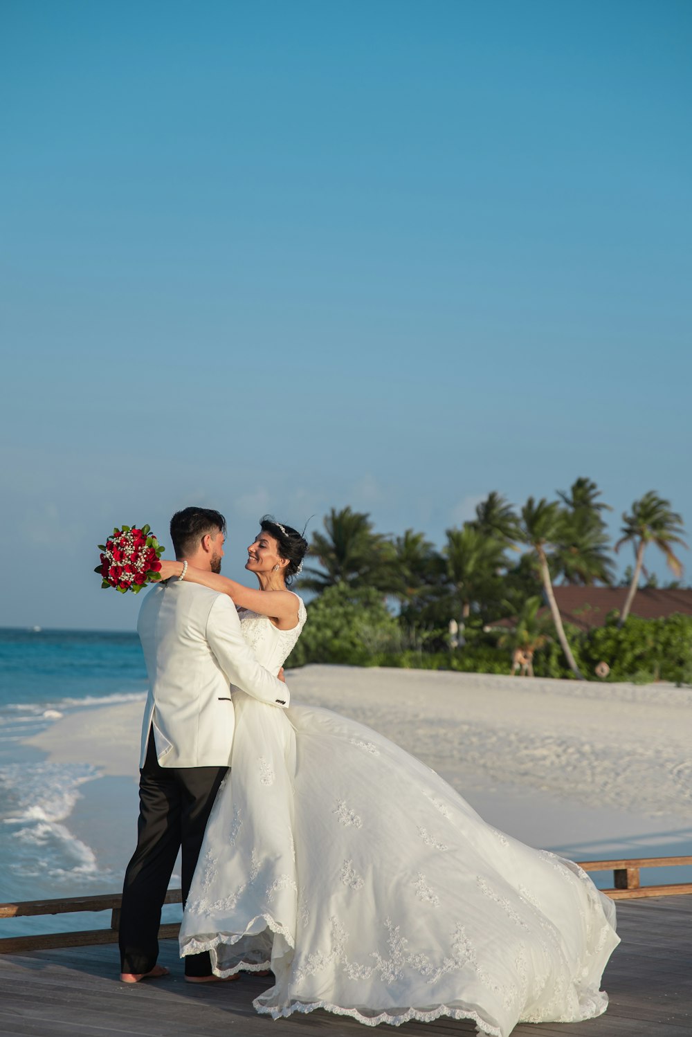 man and woman kissing on beach during daytime