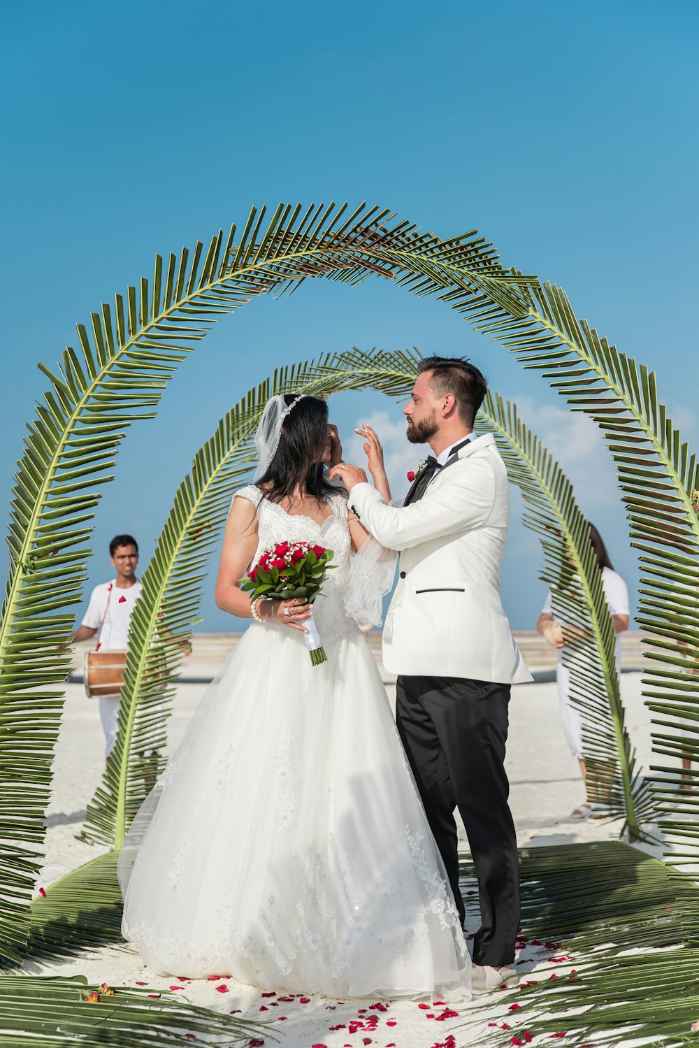 man and woman kissing under palm tree during daytime