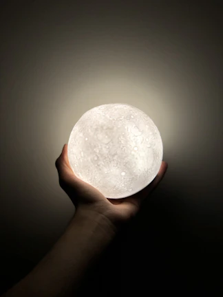 A futuristic robot hand gently holding a glowing neural network sphere.