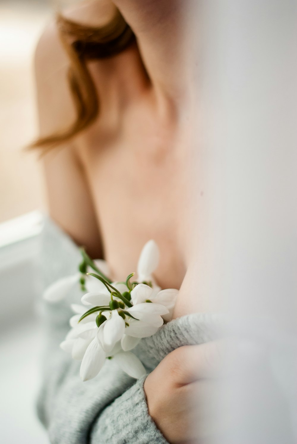 woman in white lace top holding white flower