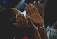 A close-up of hands raised in prayer with a soft glow of light surrounding them.