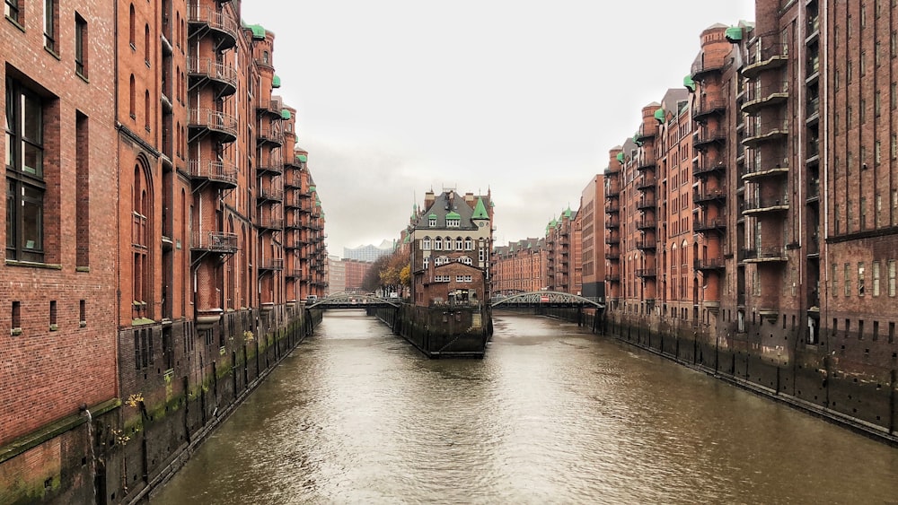 río entre edificios de hormigón marrón durante el día