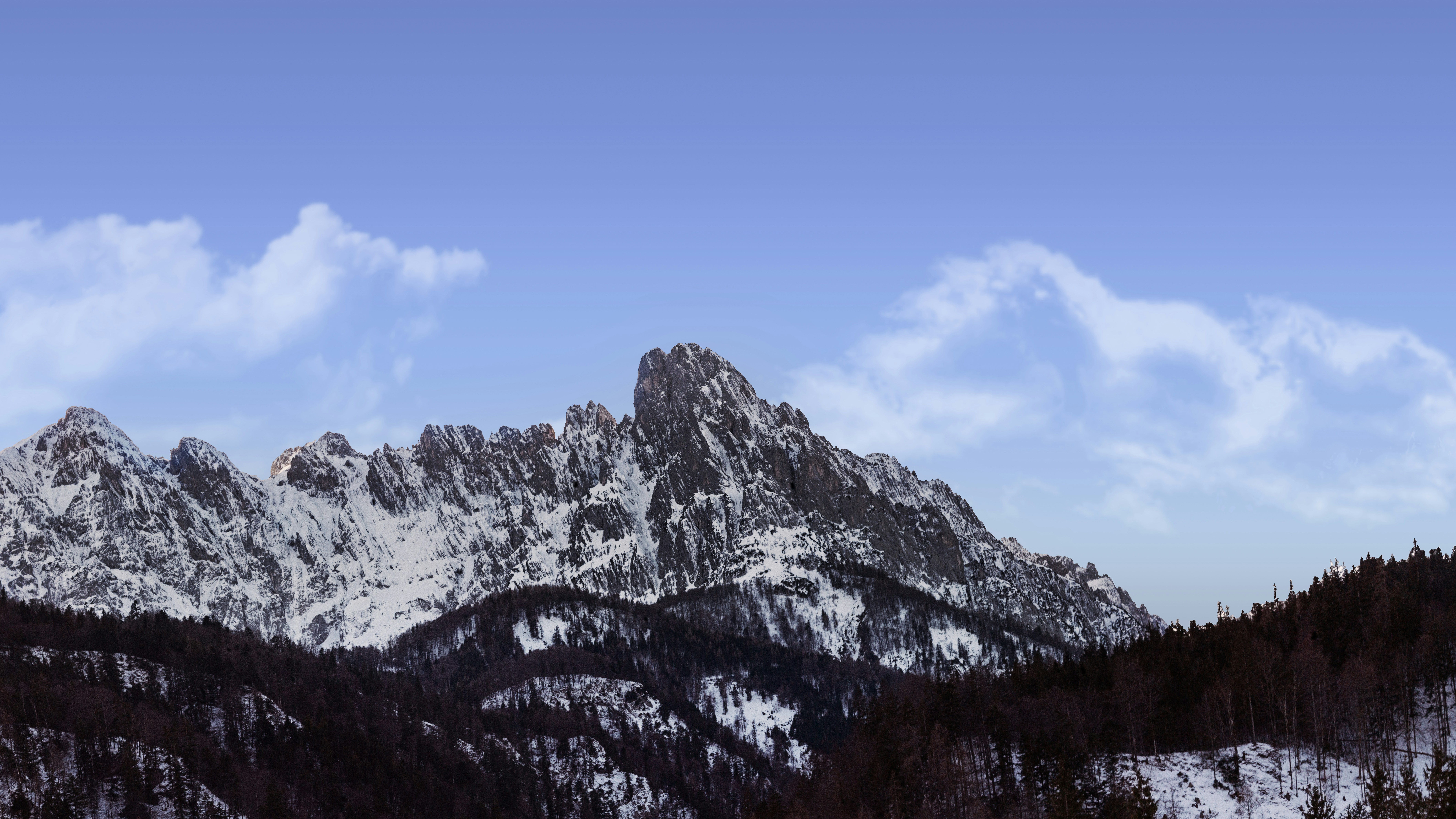 montagne enneigée sous ciel bleu pendant la journée
