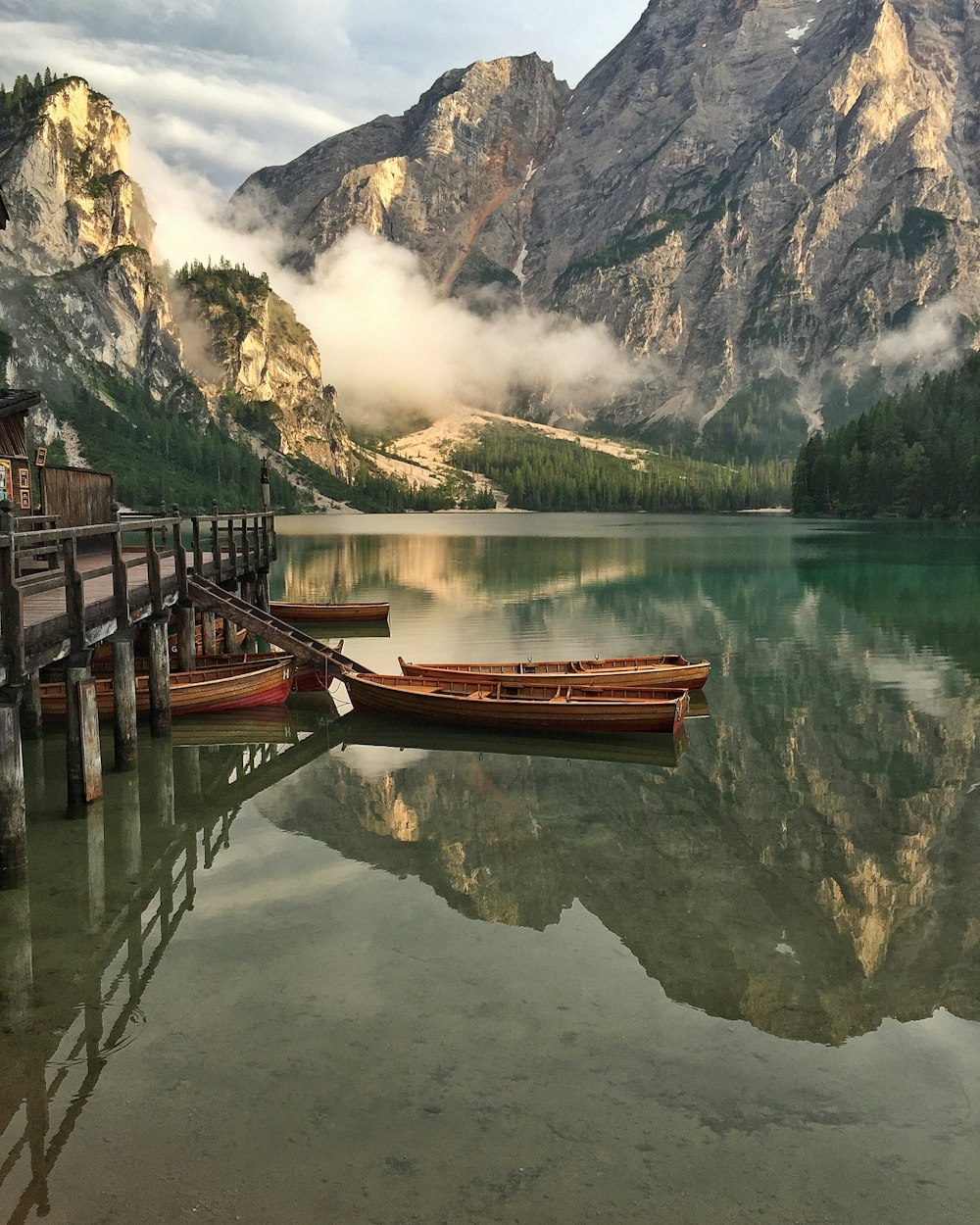 brown wooden boat on lake near brown wooden dock during daytime