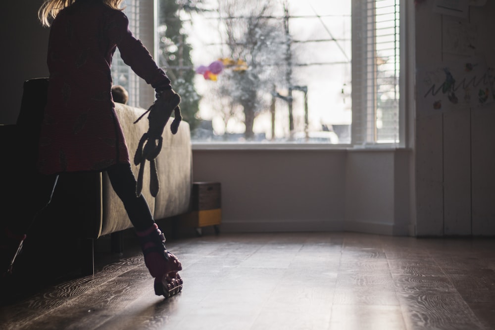 woman in black coat and black pants standing on white floor tiles