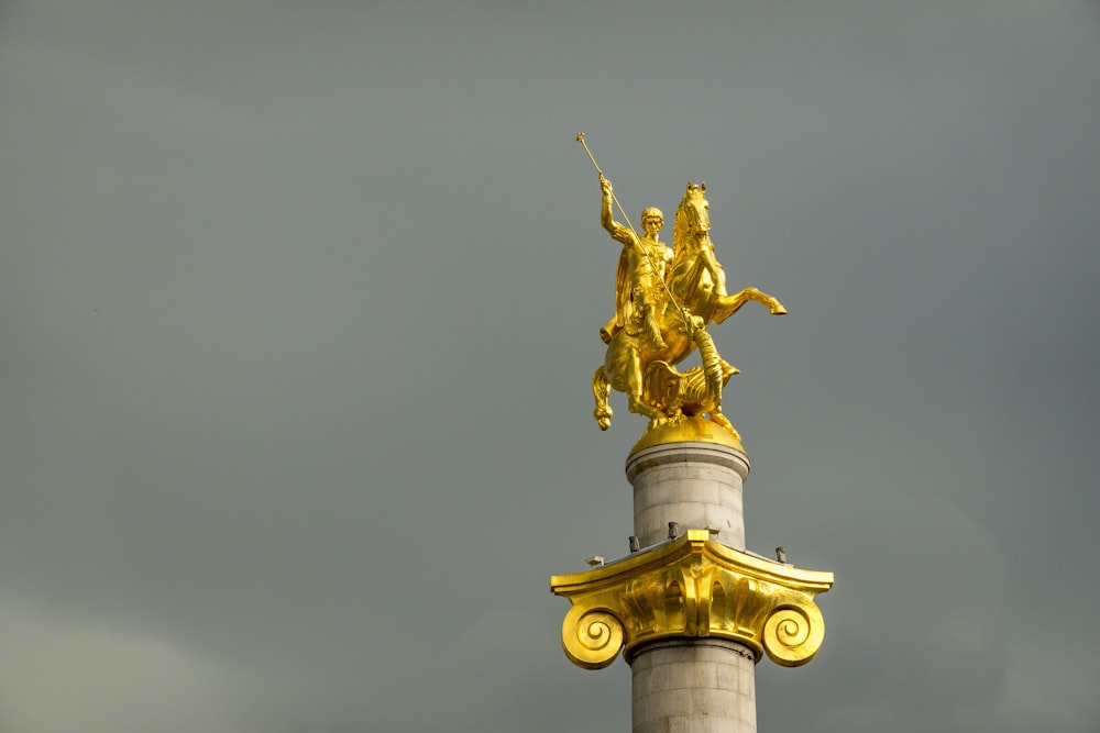 gold statue under gray sky