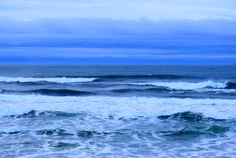 Olas oceánicas bajo el cielo azul durante el día