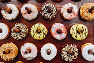 A variety of mini donuts displayed on a wooden table.
