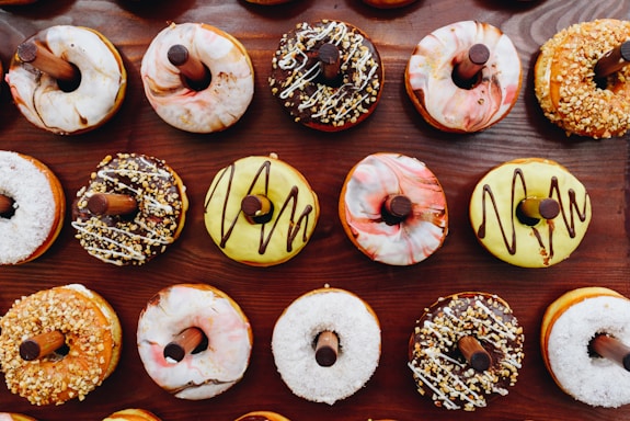 A variety of mini donuts displayed on a wooden table.
