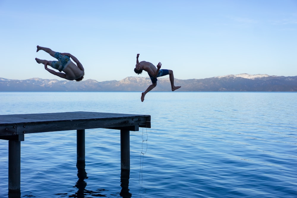 Mann in schwarzen Shorts springt tagsüber auf Wasser