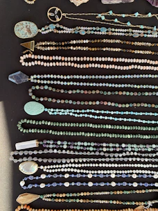 An assortment of various necklaces hanging on a display stand.