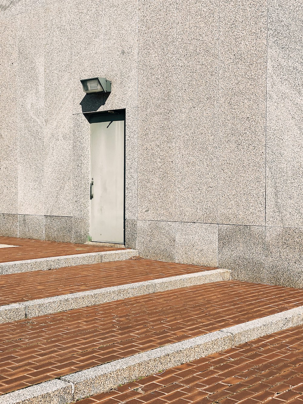 brown wooden bench near gray concrete wall