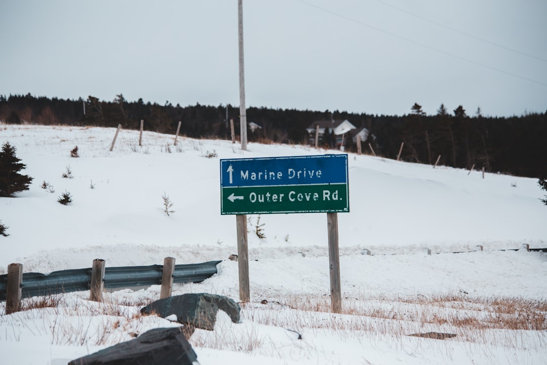 blue and white road sign on snow covered ground