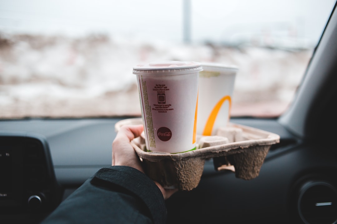 person holding white plastic cup