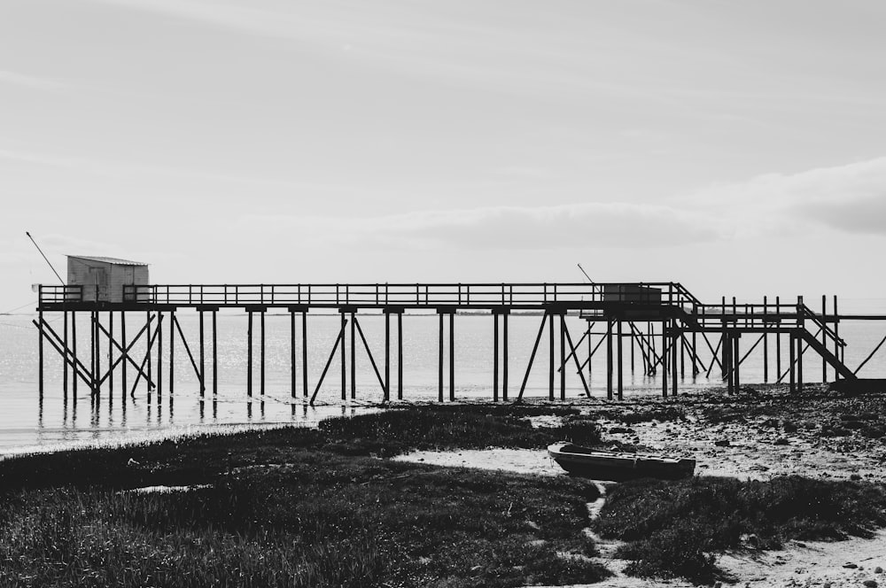 grayscale photo of bridge under cloudy sky