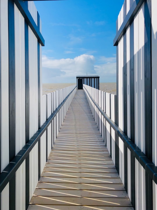 white wooden bridge under white clouds during daytime in Châtelaillon-Plage France