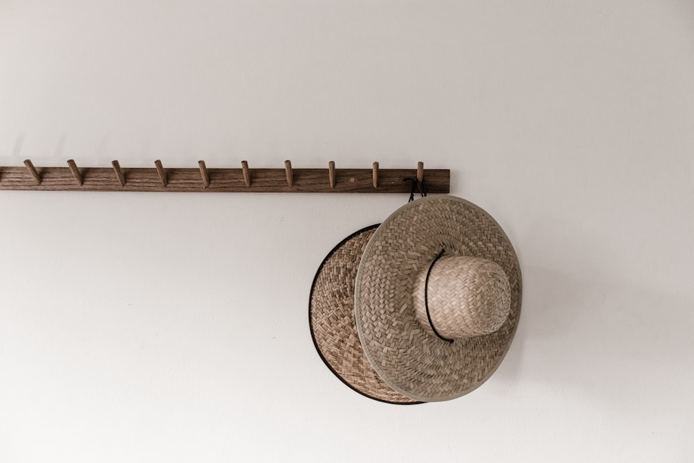 sombrero de paja marrón sobre pared blanca