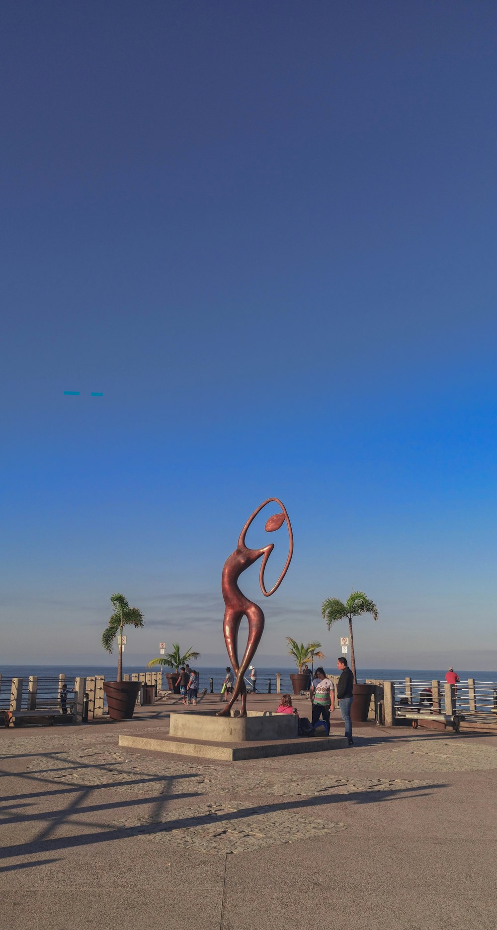 brown wooden flamingo statue near body of water during daytime