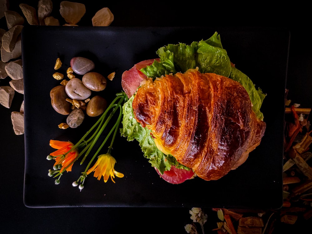 raw meat with green vegetable on black plate