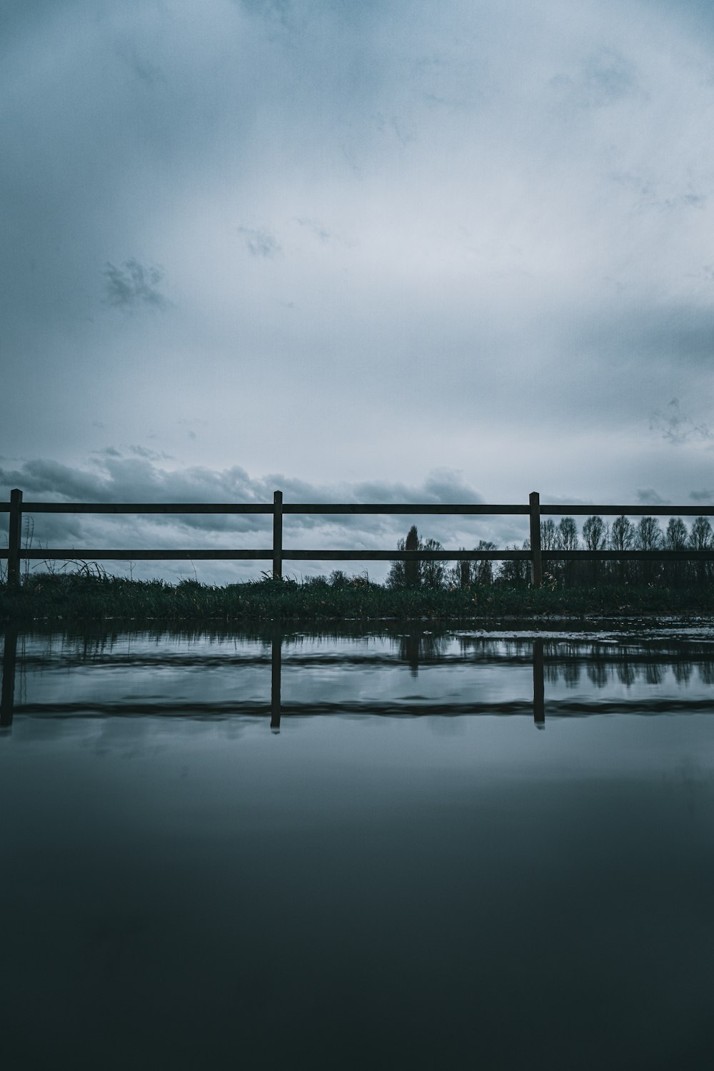 bridge over water under cloudy sky